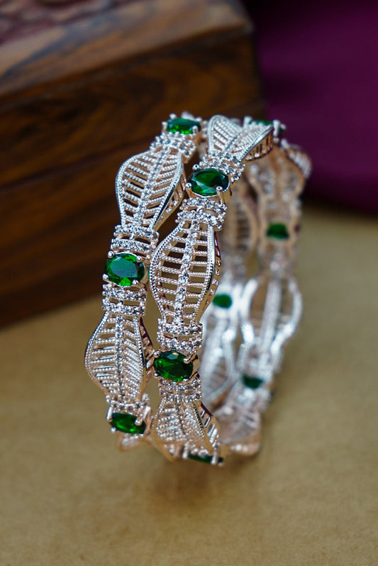 Decorative bracelet with green gemstones on a wooden surface by hitesh bangles