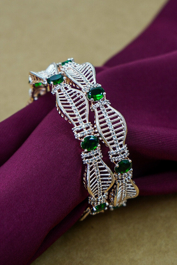 Decorative bracelet with green gemstones on a purple fabric background by hitesh bangles