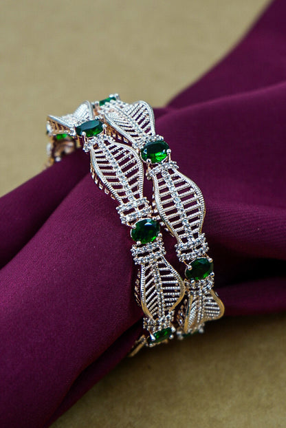Decorative bracelet with green gemstones on a purple fabric background by hitesh bangles