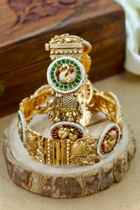 Decorative gold bracelet with elephant design on a wooden stand by hitesh bangles