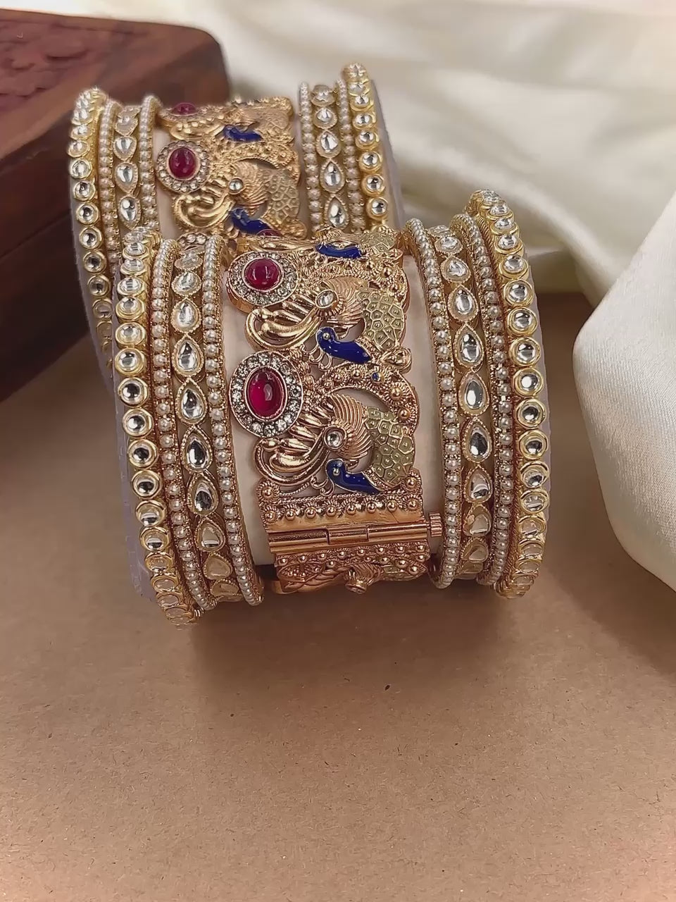 Elegant bridal gold-plated Kundan bangles featuring peacock motifs, red ruby stones, blue enamel detailing, and traditional Indian craftsmanship, perfect for wedding wear by hitesh bangles